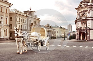 Emoty white carriage with white horse waits for tourists in central square, Kazan