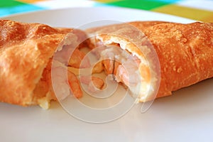 Empanadas de Camarones or Chilean Stuffed Pastry Filled with Shrimps and Cheese Cut in Half on White Plate photo