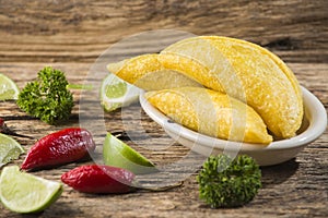 Empanadas and hot pepper on wooden background, traditional Colombian food