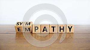 From empathy to sympathy. Turned cubes and changed the word `empathy` to `sympathy`. Beautiful wooden table, white background.