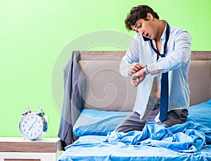 Employee in the bedroom being late for his job in time managemen