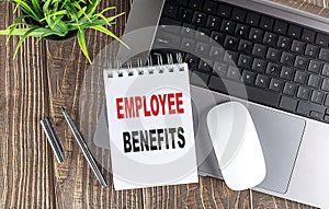 EMPLOYEE BENEFITS text on notebook with laptop, mouse and pen