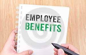 Employee benefits word on white ring binder notebook with hand h