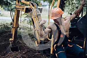 Employee concept. Employee flex biceps and triceps muscle. Strong employee at excavator cabin. Employee in working