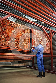 The employee corrects the Laundry hanging in the drying room, the rugs