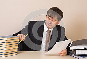 Employee counts books with documents at table in the office