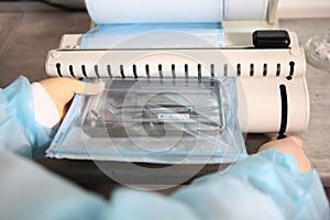 An employee of the dental clinic packs the instruments in individual packaging for subsequent sterilization. The concept of