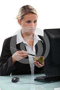 Employee eating at her computer