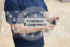 Employee Engagement on the touch screen with a blur background of the businessman with the phone.The concept of Employee Engagem