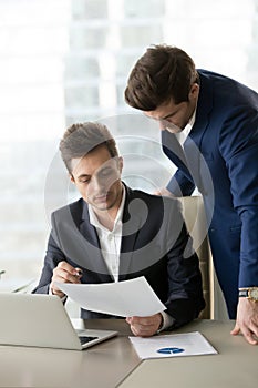 Employee explaining details in document to boss