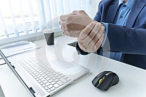 an employee feels pain in his wrist after working at the keyboard for a long time. businessman suffering from wrist pain