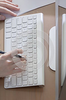 Employee female use a computer on wood desk in workplace