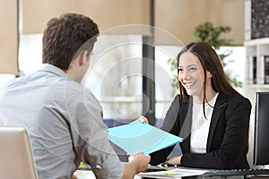 Employee giving folder to his manager during interview