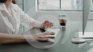 Employee with glasses uses mouse and keyboard of computer