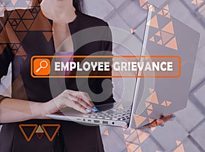 EMPLOYEE GRIEVANCE phrase on the screen. Manager use internet technologies at office. Concept search and EMPLOYEE GRIEVANCE