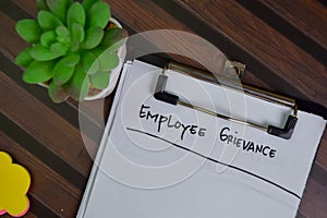 Employee Grievance write on a paperwork isolated on Wooden Table