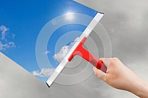 Employee hand cleaning a glass with squeegee