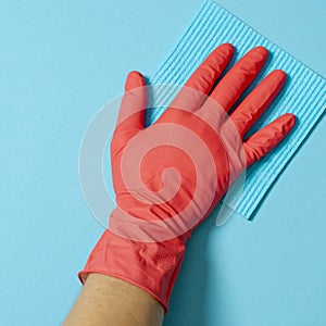 Employee hand in rubber protective glove with micro fiber cloth wiping wall from dust. Commercial cleaning company concept