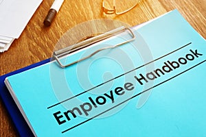 Employee handbook and clipboard on table photo