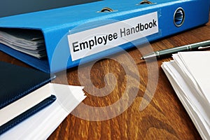 Employee Handbook manual in folder and papers