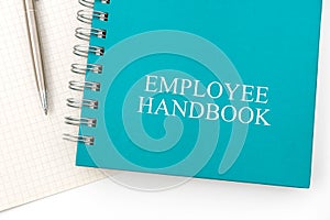 Employee Handbook or manual with a pen and paper on a white table in an office.