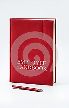 Employee Handbook or manual with a pen and paper on a white table in an office.