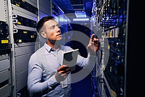 Employee inspecting hardware equipment in colocation center