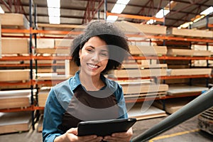 Employee looking at camera with tablet at warehouse