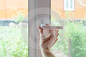 The employee opens a protective cap from the element of the plastic window. Preparing a plastic window for minor repairs