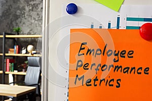 Employee performance metrics. A whiteboard with a chart and sheet attached. photo