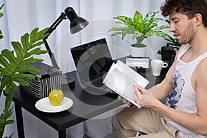 An employee quickly browses a book calendar to find the right information. A domain computer workstation among potted