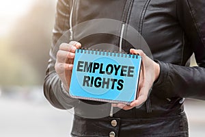 EMPLOYEE RIGHTS concept. Holding blue notebook with text