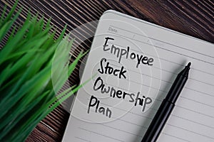 Employee Stock Ownership Plan write on a book isolated wooden table