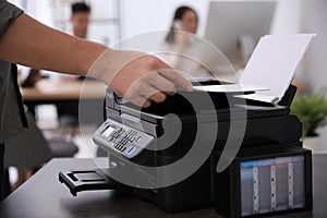 Employee using modern printer in office, closeup