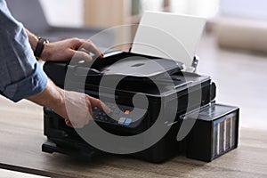 Employee using modern printer in office, closeup