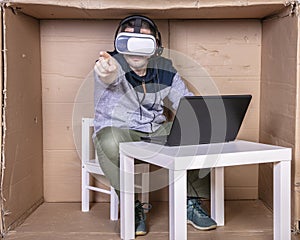 Employee with virtual reality glasses working in his home cardboard office