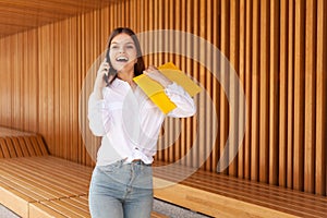 The employee was hired. The applicant was enrolled in the university and she is glad. Happy girl with a phone and a yellow folder