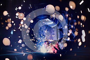 Employee welding steel with sparks using mig mag welder