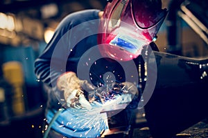 Employee welding steel with sparks using mig mag welder photo