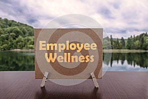 Employee wellness text on card on the table with calm lake background