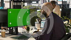 Employee at work using isolated screen PC, reading paperwork