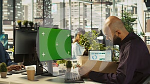 Employee at work using isolated screen PC, reading paperwork