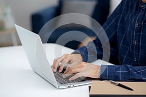 Employee young man typing and working on laptop computer on desk at home, business man using notebook surfing the internet.