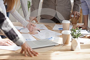 Employees brainstorm with documents on table during meeting