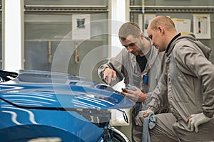 Employees of the car body painting shop check the quality