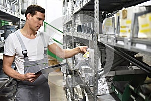 Employees of a car repair shop in a warehouse for spare parts photo