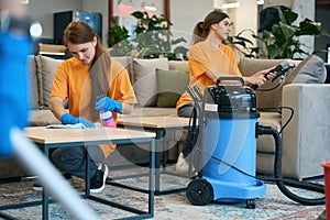 Employees of the cleaning company make thorough cleaning of furniture