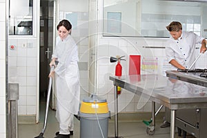 Employees cleaning restaurant kitchen after service