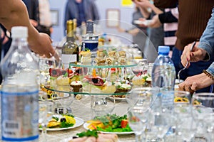 Employees of the company at the Banquet. Table with delicacies, alcohol and snacks. A gala reception