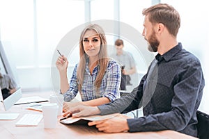 Employees discussing financial data sitting at the office table